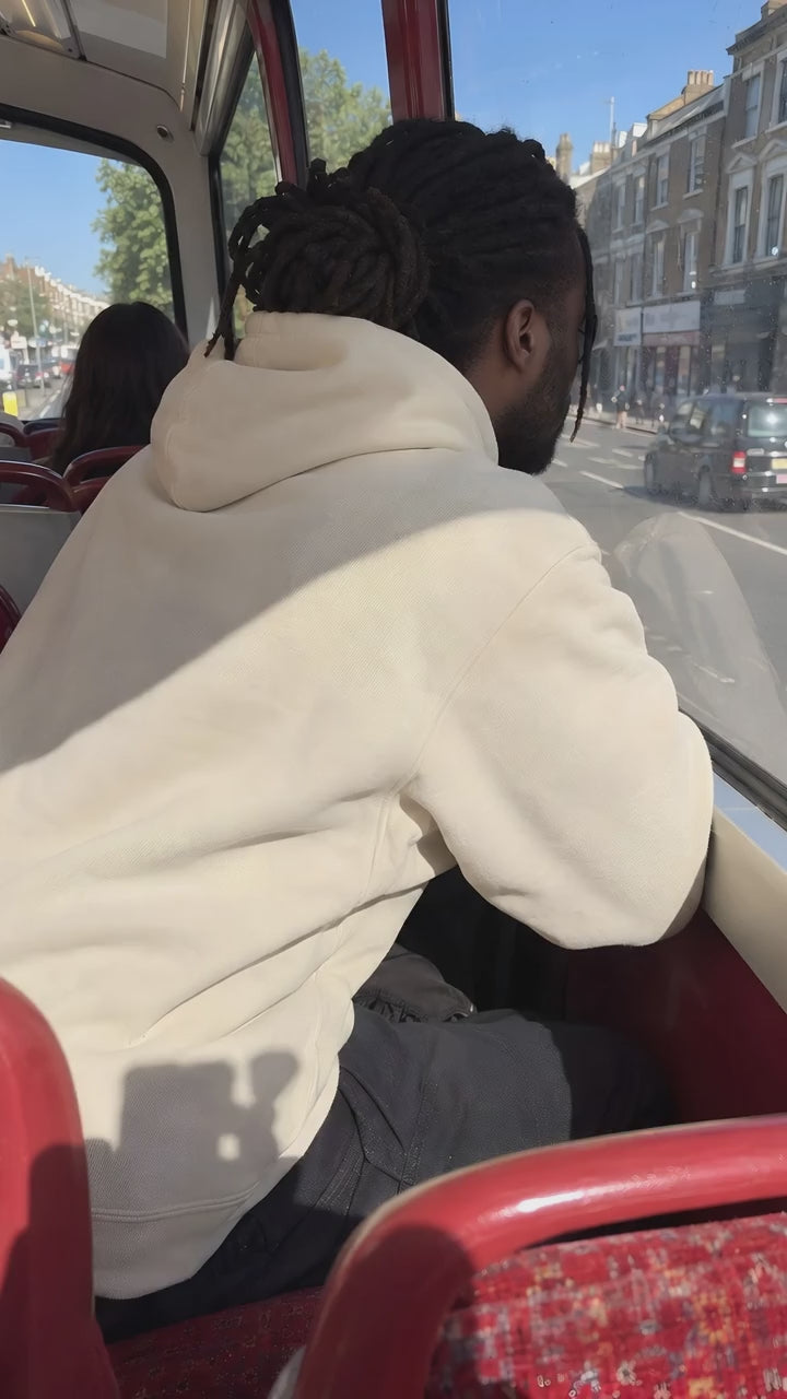 A man in the ENVY Hoodie on the front seat of a bus top deck