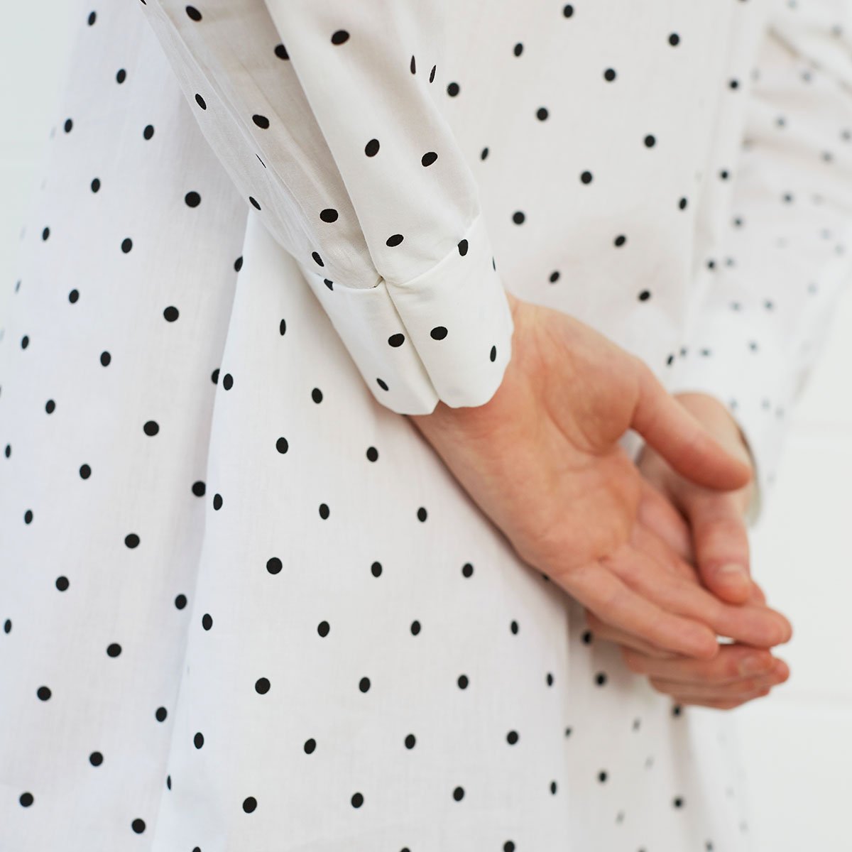 Close up of woman wearing polka dot shirt dress